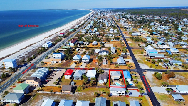 bird's eye view featuring a water view and a beach view