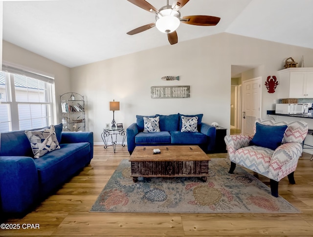 living room with light hardwood / wood-style flooring, vaulted ceiling, and ceiling fan