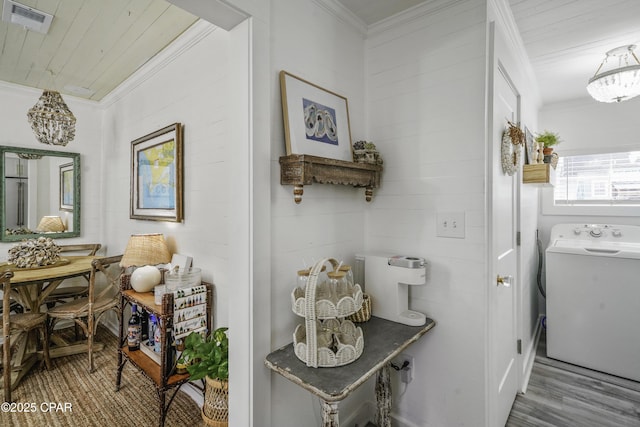 interior space with crown molding, washer / dryer, hardwood / wood-style floors, and wooden ceiling