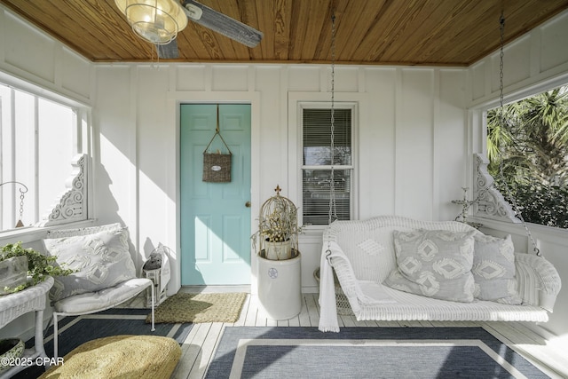 sunroom / solarium featuring plenty of natural light, wooden ceiling, and ceiling fan