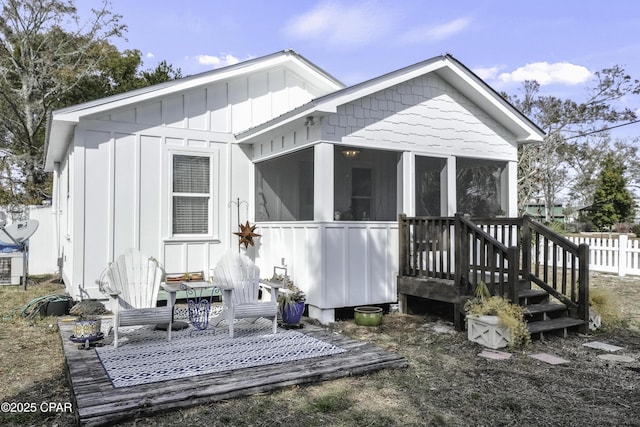 rear view of property featuring a sunroom