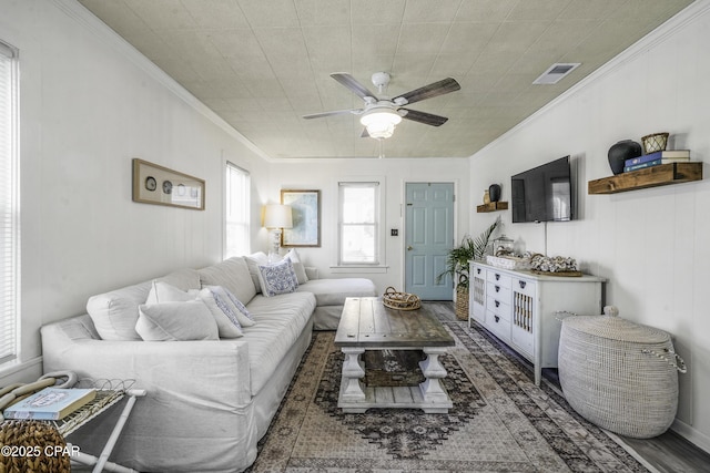 living room with dark hardwood / wood-style flooring, ornamental molding, and ceiling fan