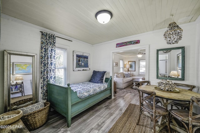 bedroom with crown molding, wood ceiling, hardwood / wood-style floors, and multiple windows