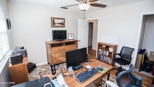 home office with hardwood / wood-style flooring and ceiling fan