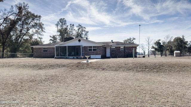 rear view of property featuring a sunroom