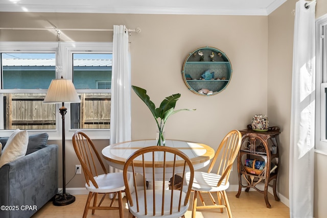 living area with crown molding and light hardwood / wood-style flooring