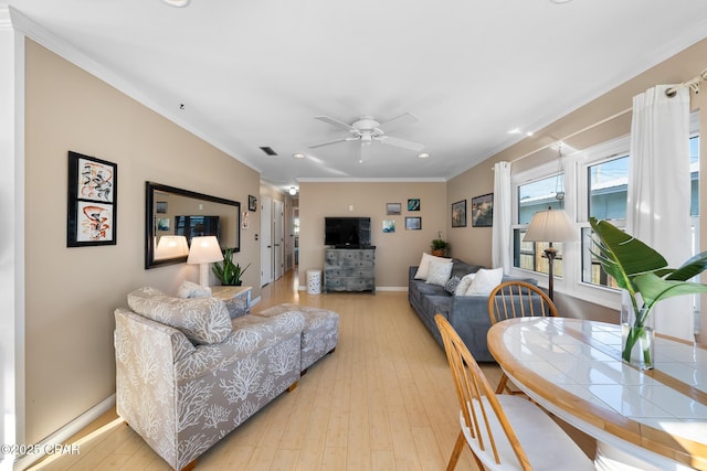 living room with crown molding, ceiling fan, and light hardwood / wood-style flooring