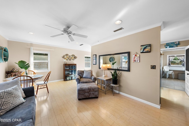 living room with crown molding, ceiling fan, and light wood-type flooring