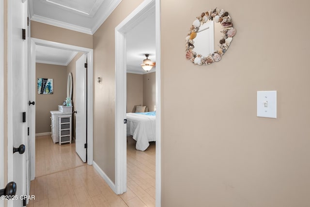 corridor with crown molding and light hardwood / wood-style floors