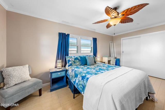 bedroom with crown molding, ceiling fan, light wood-type flooring, and a closet