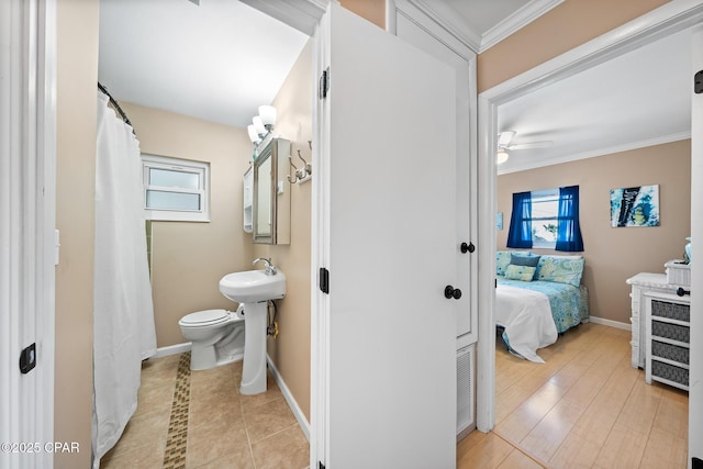 21823 Marlin Ave, Panama City Beach, FL 32413 - bathroom featuring crown molding, toilet, ceiling fan, baseboards, and a sink