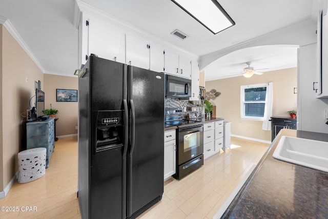 kitchen featuring sink, light hardwood / wood-style flooring, white cabinetry, ornamental molding, and black appliances