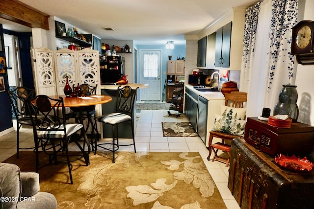 kitchen featuring black refrigerator, sink, light tile patterned floors, and dishwasher