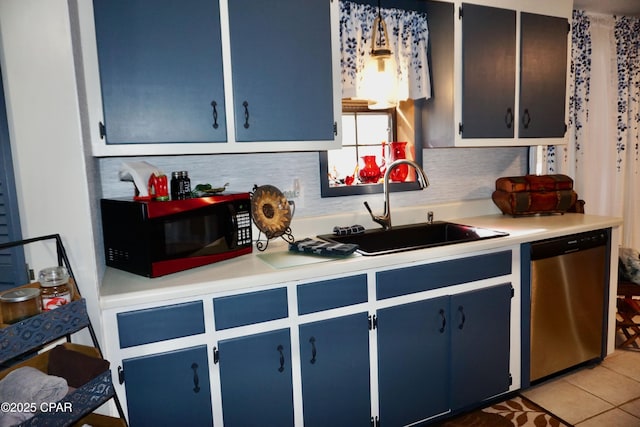 kitchen featuring hanging light fixtures, stainless steel dishwasher, sink, and blue cabinets