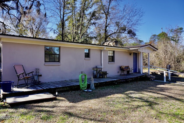 rear view of house with a yard and a deck