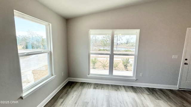 unfurnished room featuring plenty of natural light and hardwood / wood-style floors