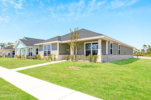 1202 Danley St, Panama City, FL 32404 - view of front facade featuring a shingled roof, a front yard, and brick siding