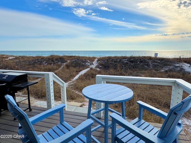 balcony with a water view and a view of the beach