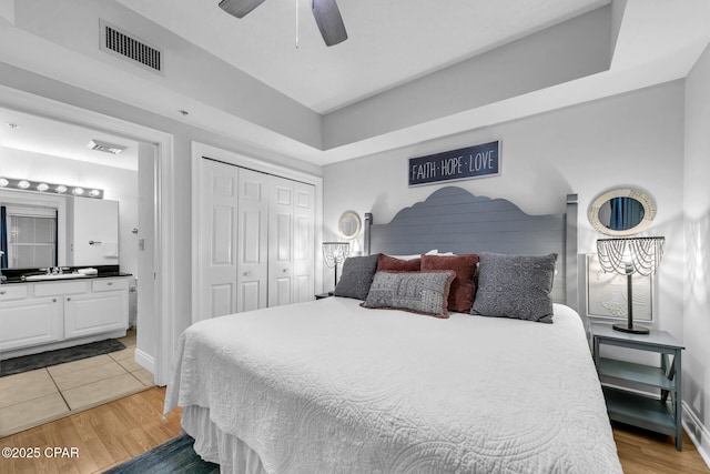 bedroom with sink, ceiling fan, hardwood / wood-style floors, connected bathroom, and a closet