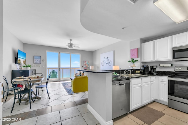 kitchen with sink, kitchen peninsula, white cabinets, and appliances with stainless steel finishes