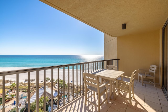 balcony featuring a water view and a beach view