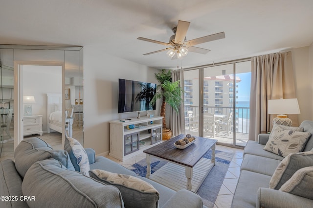 living room with light tile patterned floors, expansive windows, and ceiling fan