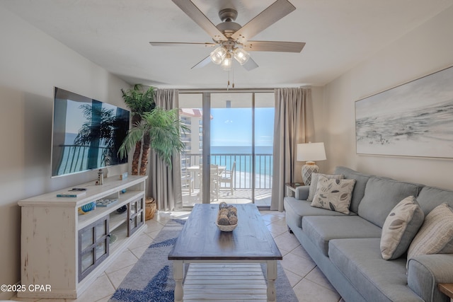 living room featuring expansive windows, light tile patterned floors, and ceiling fan