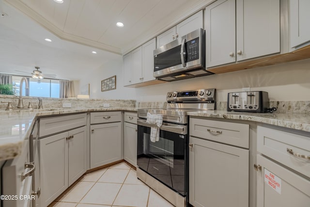 kitchen featuring light tile patterned flooring, appliances with stainless steel finishes, sink, ornamental molding, and light stone counters