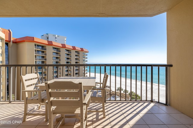 balcony featuring a view of the beach and a water view