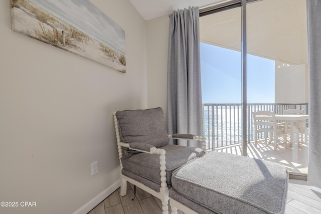 living area with hardwood / wood-style flooring and a water view