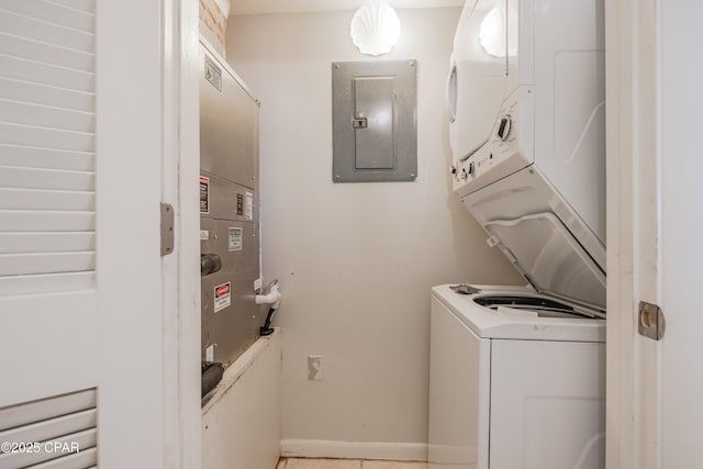 laundry area featuring stacked washer / drying machine and electric panel