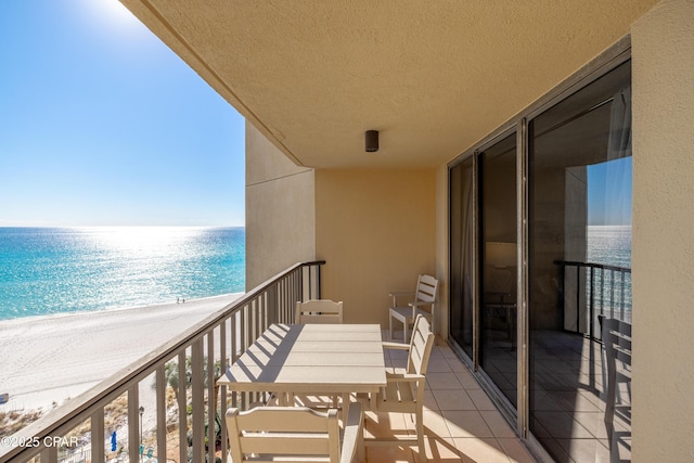 balcony featuring a water view and a beach view