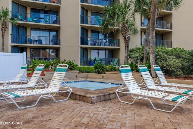 view of swimming pool featuring a hot tub and a patio