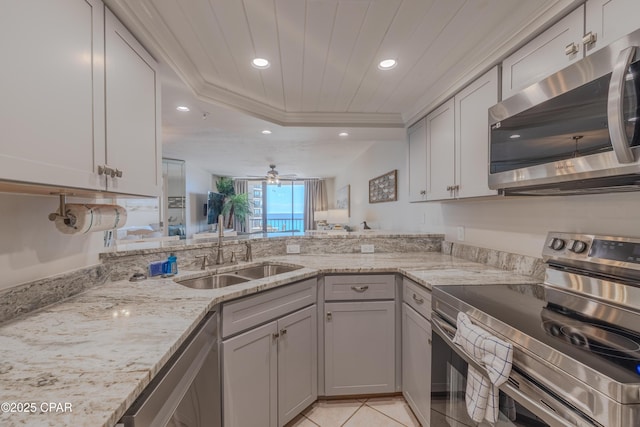 kitchen with a raised ceiling, sink, wood ceiling, light stone counters, and stainless steel appliances