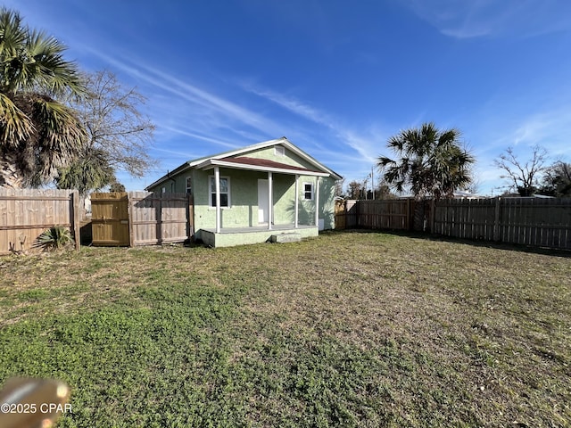 rear view of house featuring a lawn