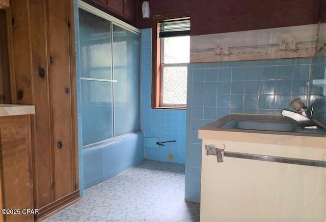 bathroom with vanity, shower / bathtub combination, and tile walls