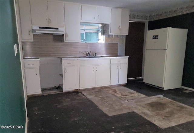 kitchen featuring white cabinetry, white fridge, sink, and backsplash