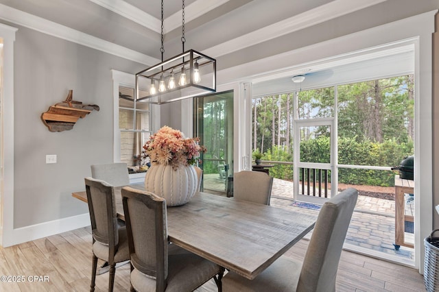 22207 Fox Glenn Trce, Panama City Beach, FL 32413 - dining room featuring light wood-type flooring, ornamental molding, baseboards, a tray ceiling, and a chandelier