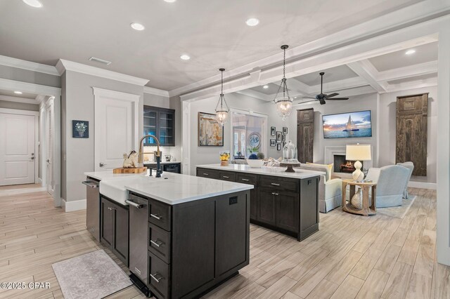 22207 Fox Glenn Trce, Panama City Beach, FL 32413 - kitchen with an island with sink, ceiling fan, a sink, baseboards, and ornamental molding
