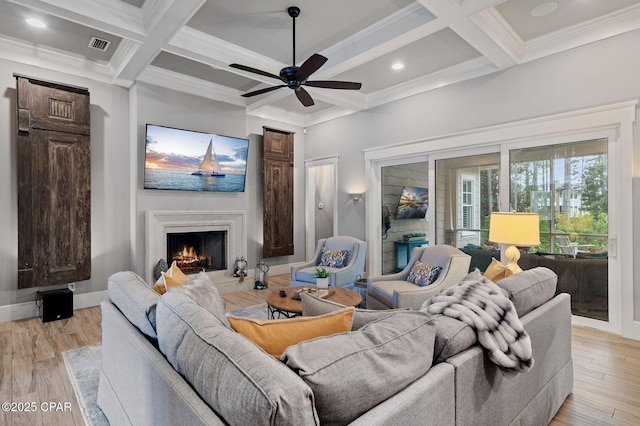 22207 Fox Glenn Trce, Panama City Beach, FL 32413 - living area with coffered ceiling, a lit fireplace, ceiling fan, beamed ceiling, and crown molding