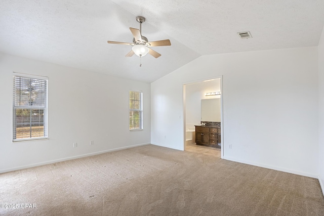 carpeted spare room with ceiling fan, lofted ceiling, and a textured ceiling