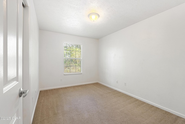 carpeted empty room with a textured ceiling