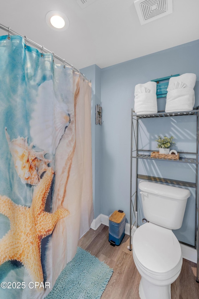 bathroom with hardwood / wood-style flooring and toilet