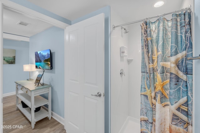 bathroom featuring hardwood / wood-style flooring and a shower with shower curtain