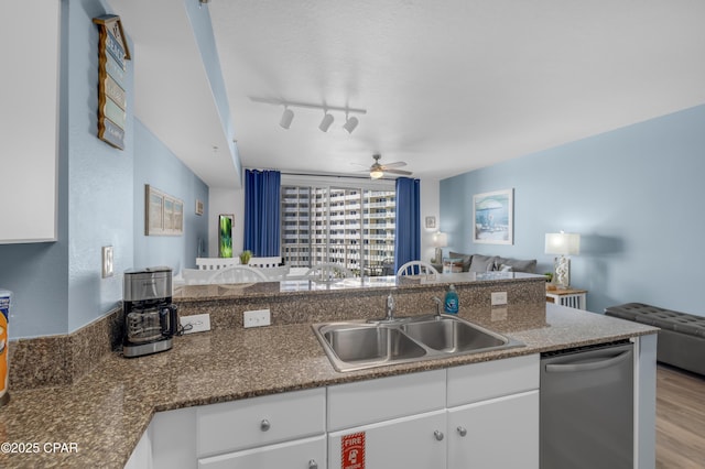 kitchen with sink, light hardwood / wood-style flooring, dishwasher, white cabinets, and kitchen peninsula