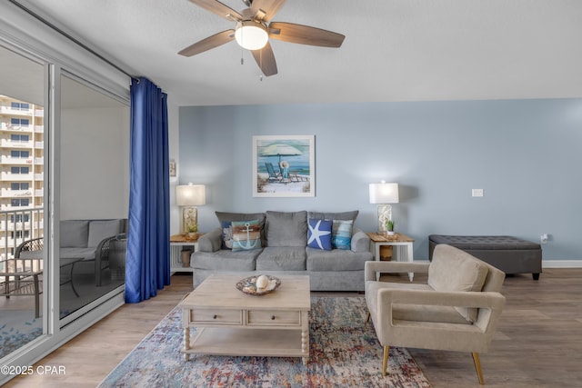 living room with ceiling fan and light wood-type flooring