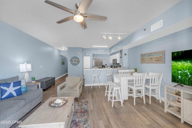 living room featuring ceiling fan and light wood-type flooring