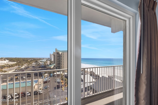 balcony featuring a view of the beach and a water view