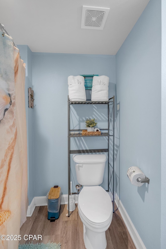 bathroom with wood-type flooring and toilet