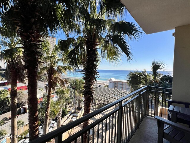 balcony featuring a beach view and a water view